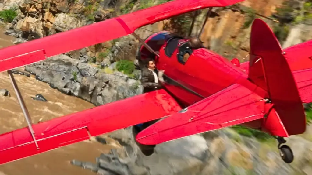 Tom Cruise hanging to an airplane as shown in Mission: Impossible- The Final Reckoning (Image via Paramount Pictures)